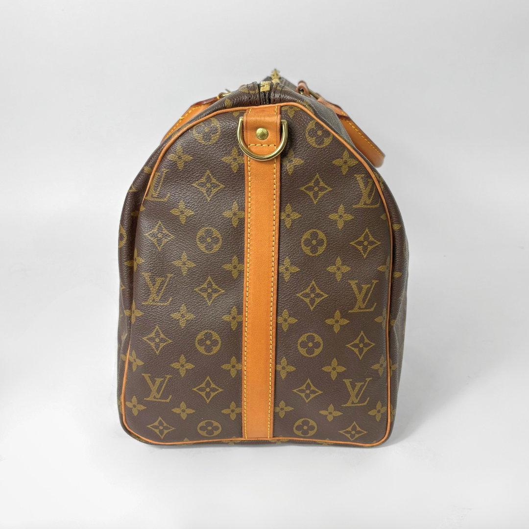 Brown leather bag with gold monogram pattern on a white background