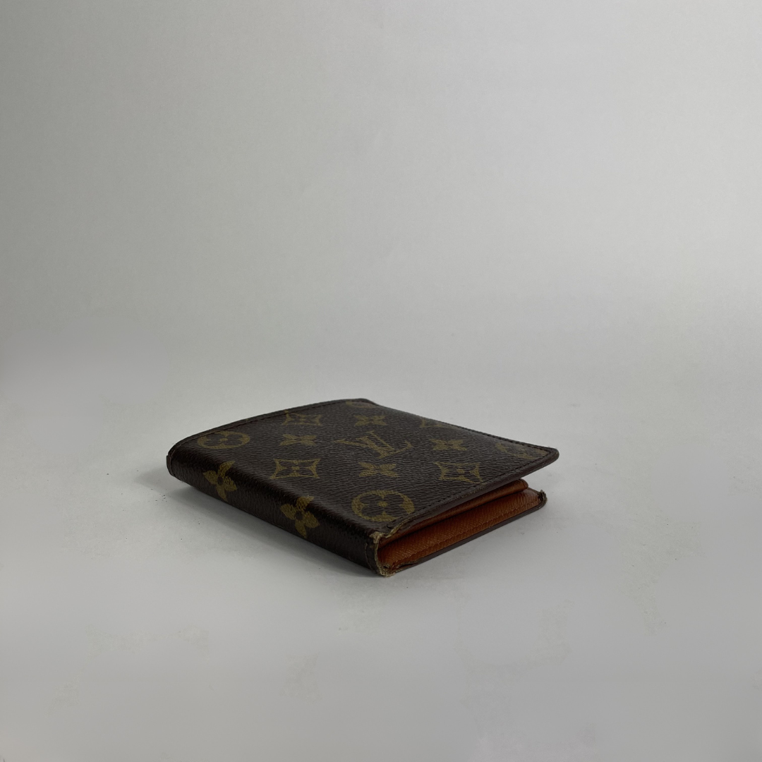 A classic Louis Vuitton monogram bifold wallet in dark brown coated canvas with tan monogram motifs, shown closed on a light gray background.