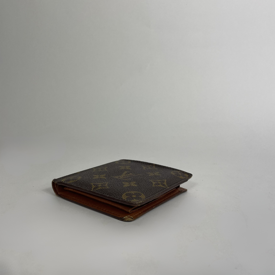A Louis Vuitton monogram canvas bifold wallet in dark brown with tan monogram motifs and a brown leather edge, photographed on a light gray studio background.