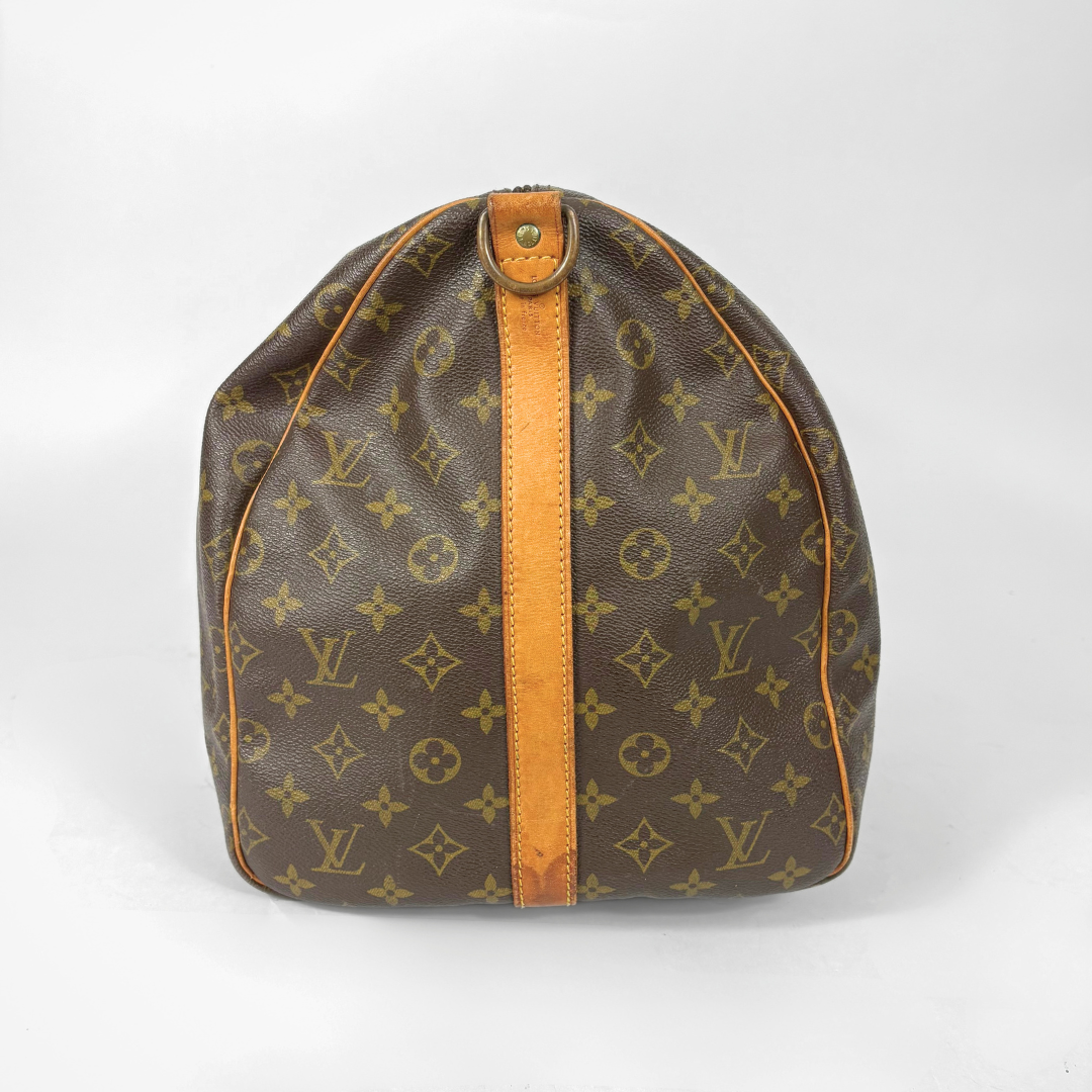 Louis Vuitton monogram travel bag with brown handles on a white background