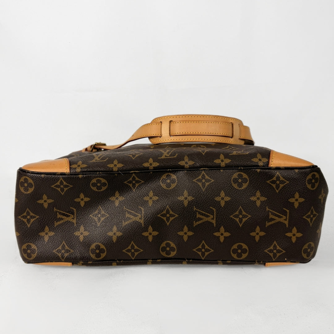A Louis Vuitton monogram canvas duffel bag with tan leather trim and handle, shown from the side against a plain white background.