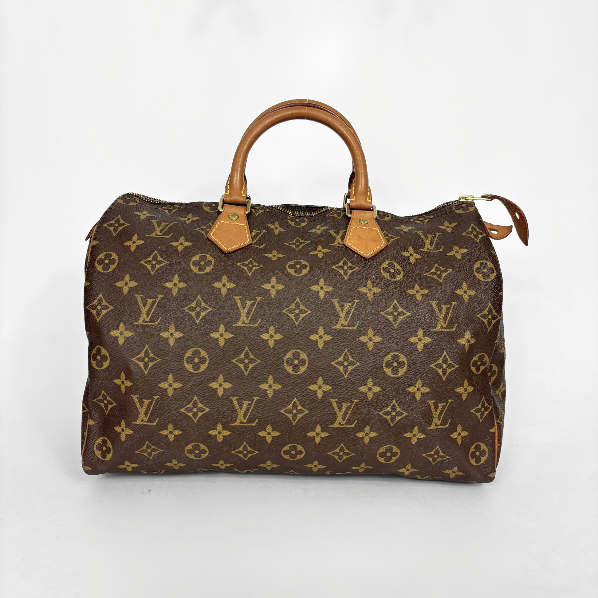 Bolso marrón con estampado de monograma sobre fondo blanco.