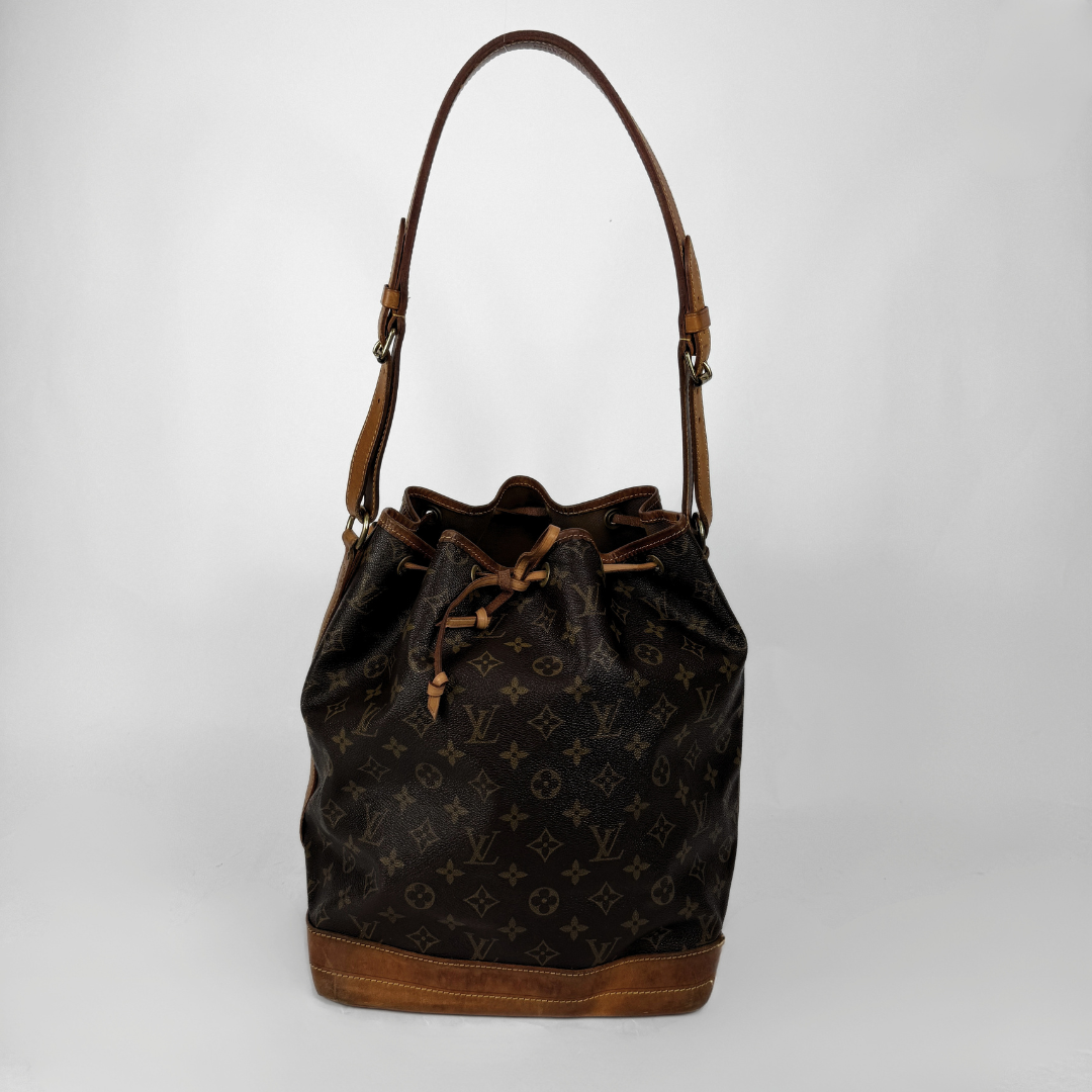 Louis Vuitton monogram canvas bucket bag with brown leather trim and shoulder strap, shown on a light gray background.