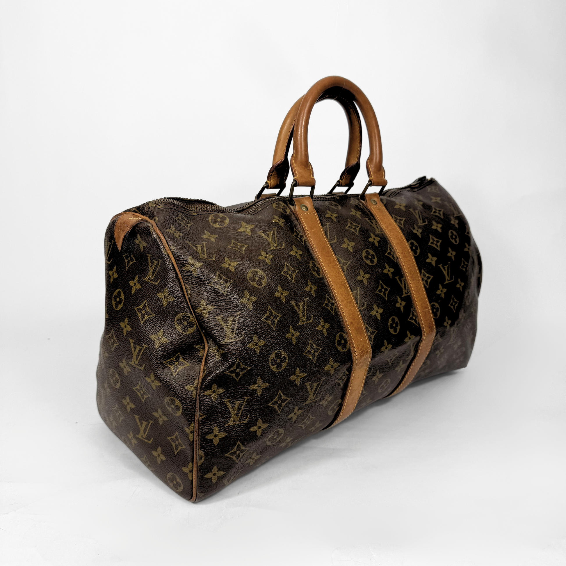 Brown travel bag with tan leather straps on a white background