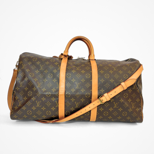 Brown LV duffel bag with monogram canvas and tan leather straps on a white background