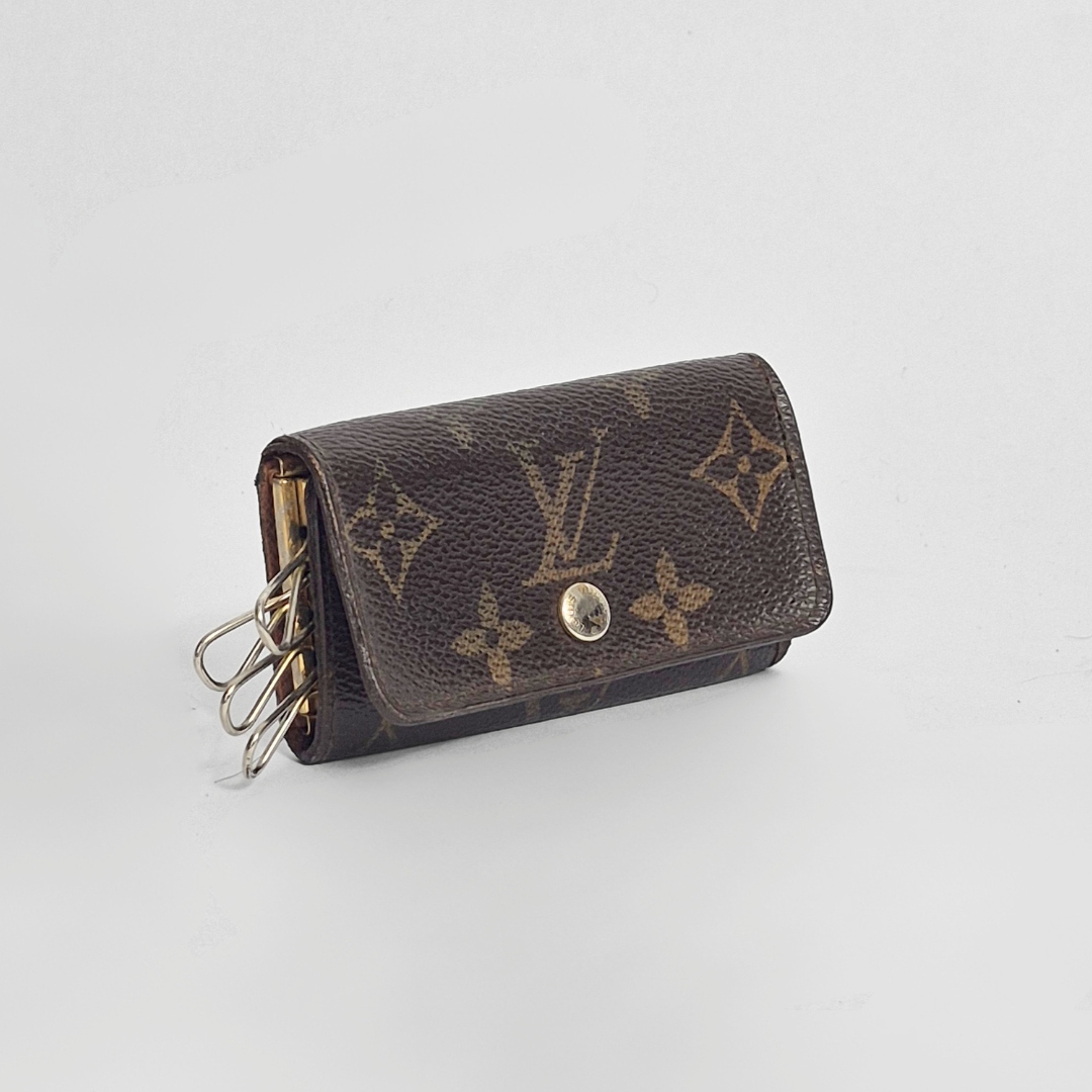 Louis Vuitton wallet with monogram pattern on a light gray background