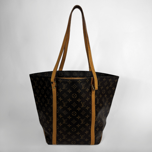 Louis Vuitton monogram canvas tote bag with tan leather shoulder straps and trim, shown against a plain light gray background.
