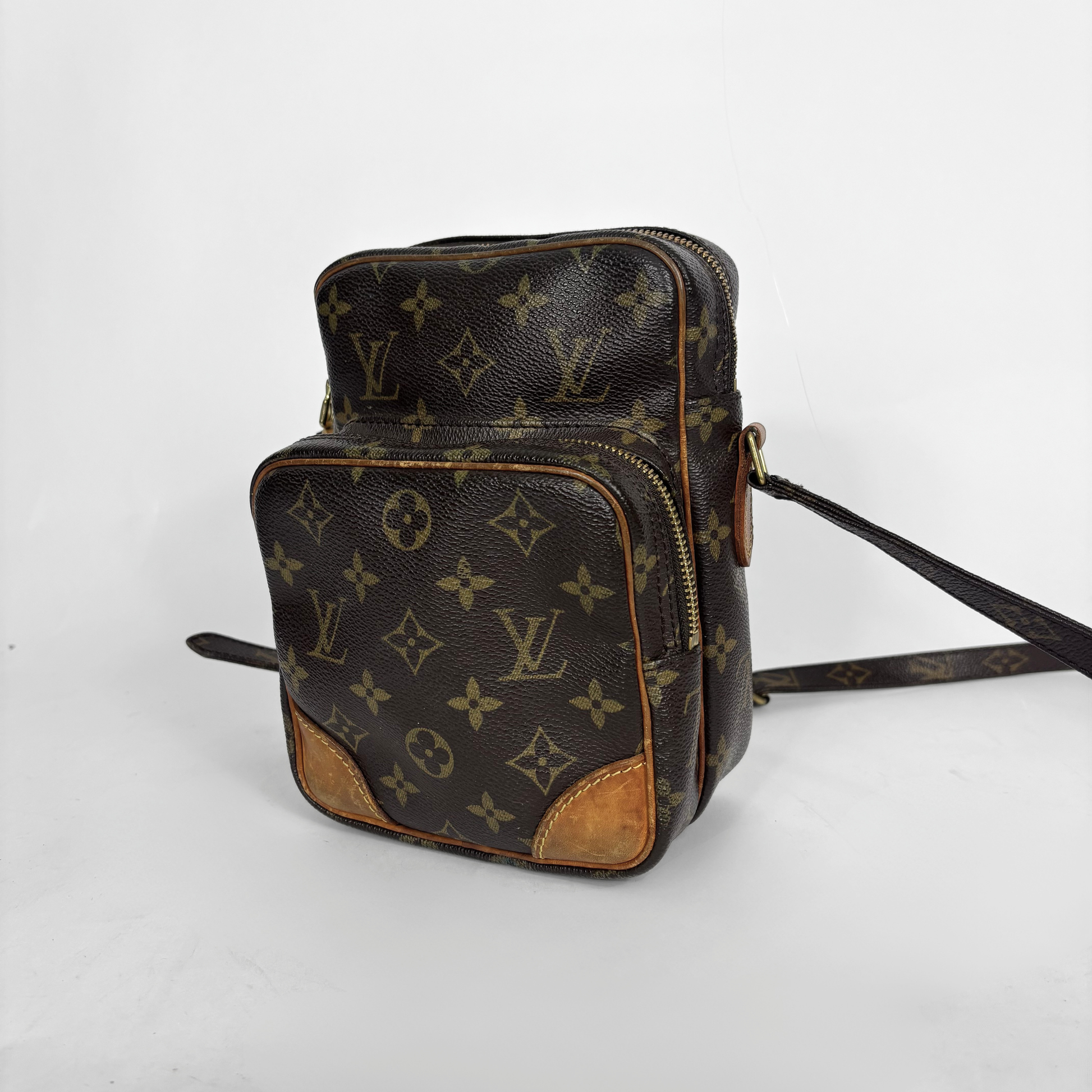 Brown leather bag with monogram pattern on a white background