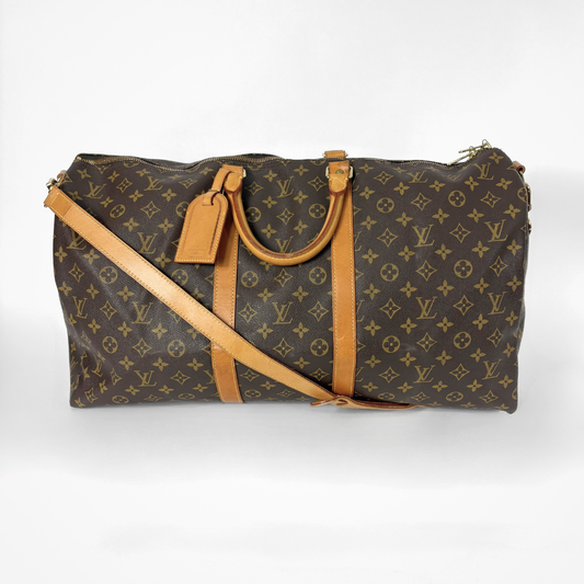Brown monogram duffel bag with tan leather straps on a white background