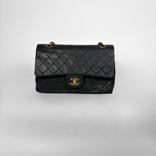 Black quilted Chanel shoulder bag with gold hardware on a white background