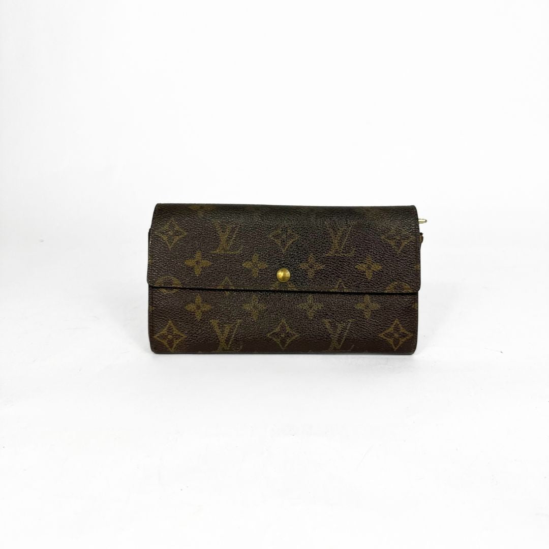 Louis Vuitton wallet with monogram pattern on a white background
