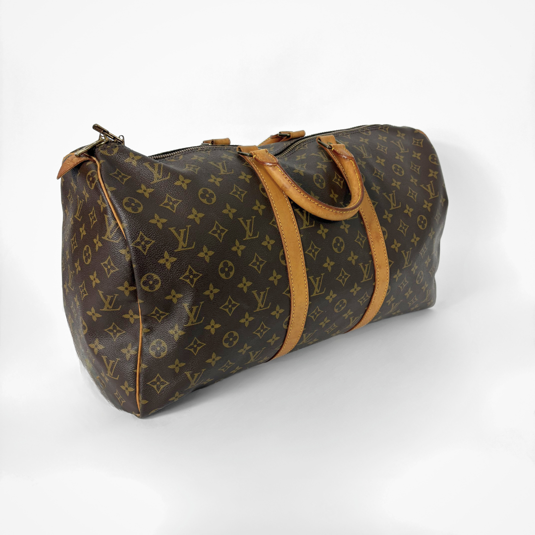 Louis Vuitton monogram travel bag with brown leather straps on a white background
