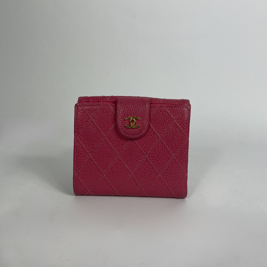 A vintage Chanel wallet in magenta pink textured leather with a gold-tone interlocking CC logo on the front flap, set against a neutral gray background.