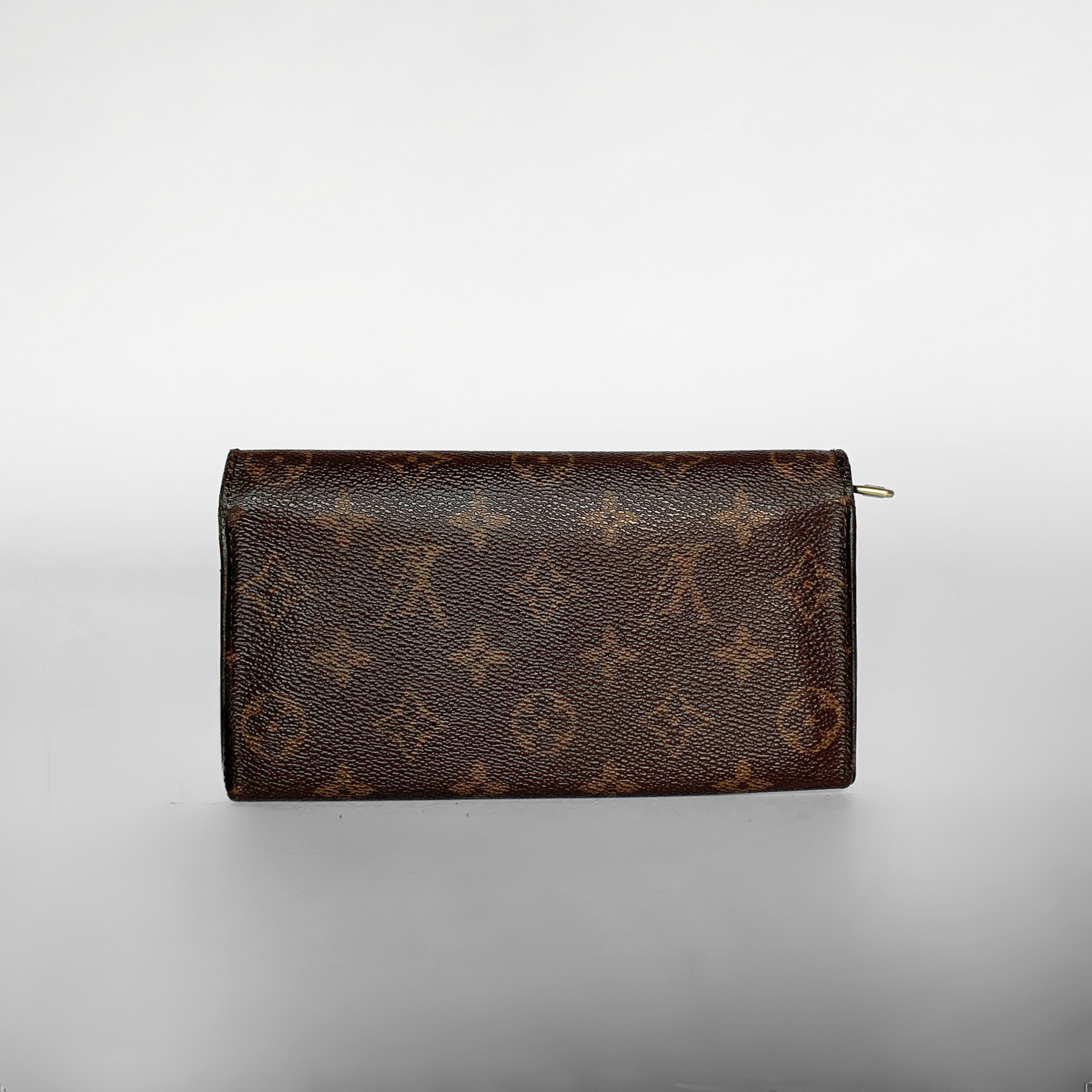 A Louis Vuitton monogram canvas zip-around wallet in dark brown with tan monogram motifs, photographed on a light gray gradient background.