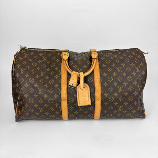 Brown leather bag with gold monogram pattern on a white background