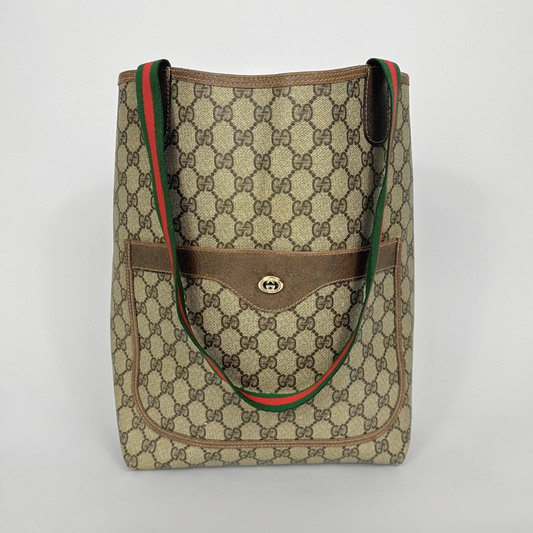 Designer handbag with patterned fabric and brown accents on a light gray background