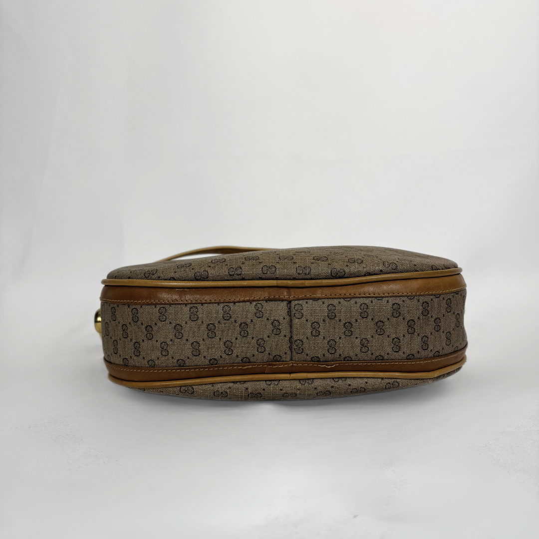 A vintage Gucci monogram canvas pouch or small bag shown from the side against a plain white background.