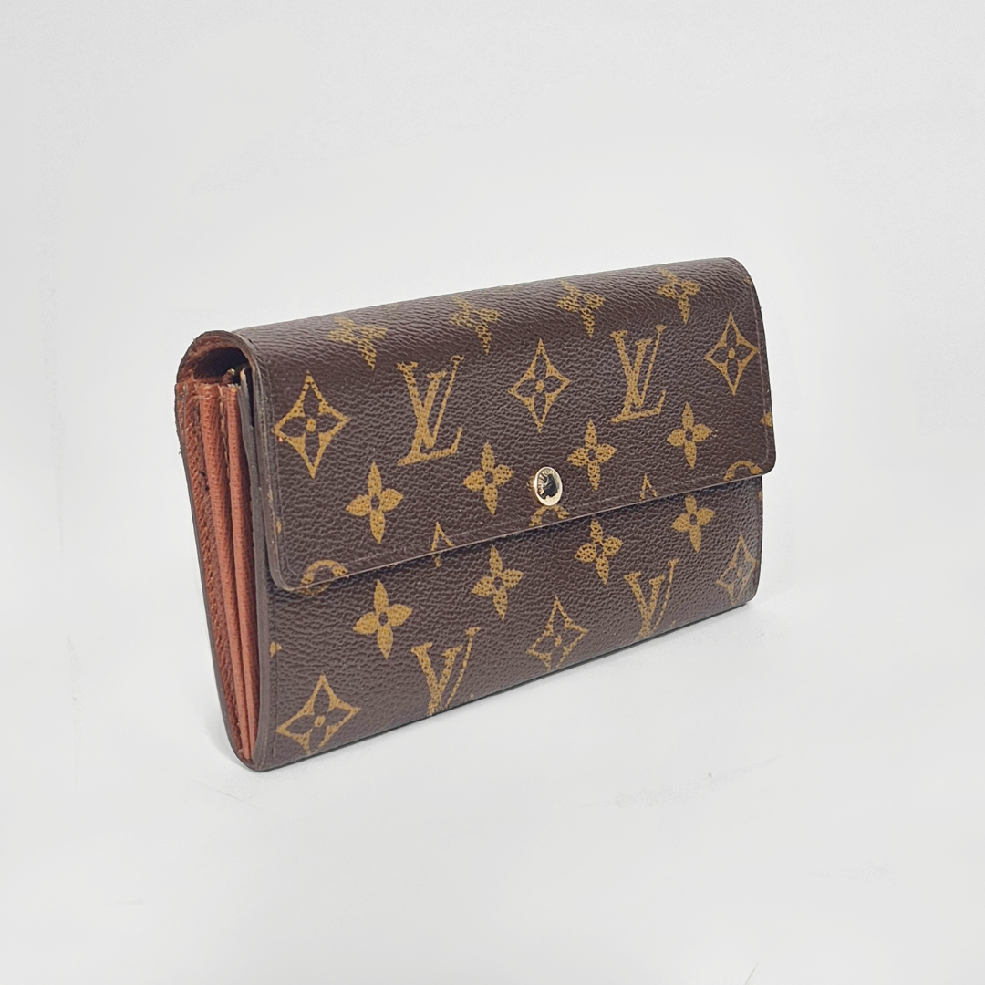 Brown wallet with gold monogram pattern on a white background