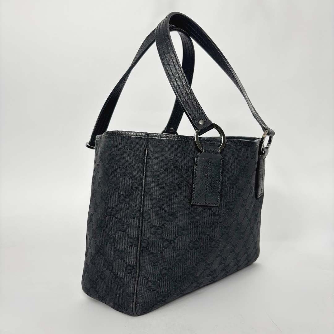 Bolso negro texturizado sobre fondo gris claro