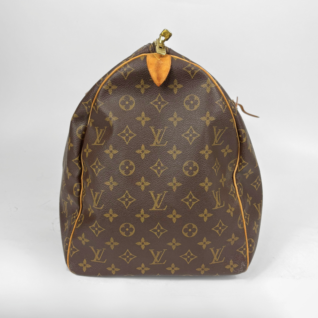 Brown leather backpack with gold monogram pattern on a white background