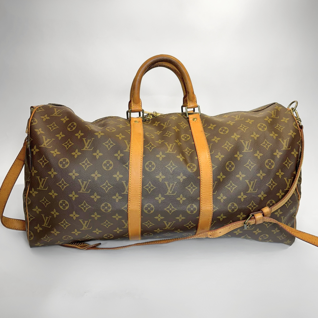 Brown leather duffel bag with tan straps on a white background