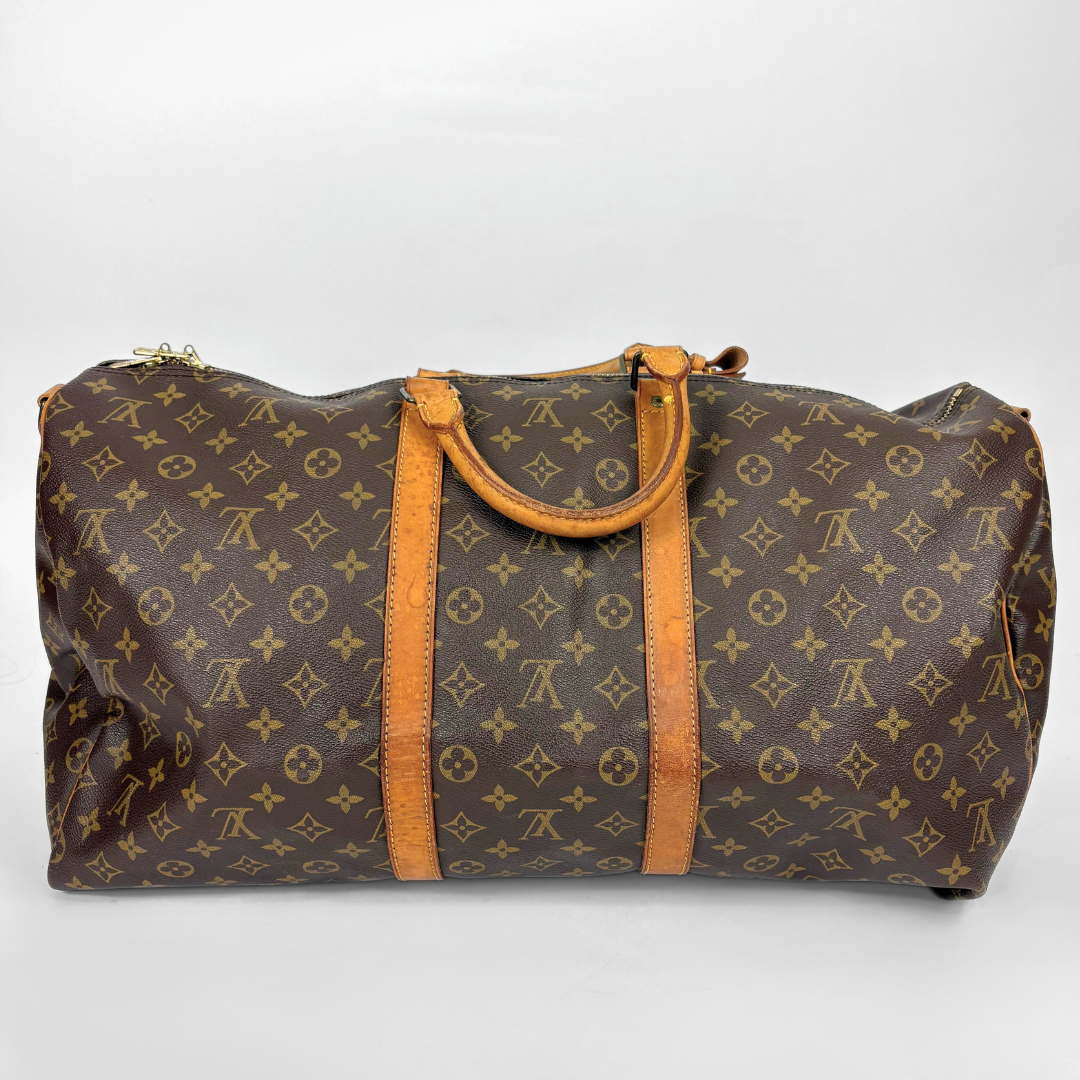 Brown duffel bag with tan leather straps and handle on a white background