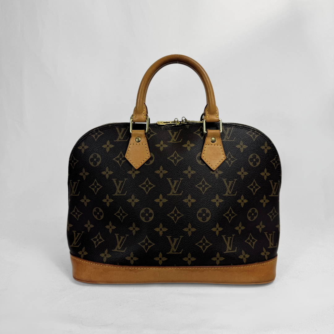 Louis Vuitton monogram canvas top-handle satchel in black with tan leather trim and handles, photographed against a white studio background.