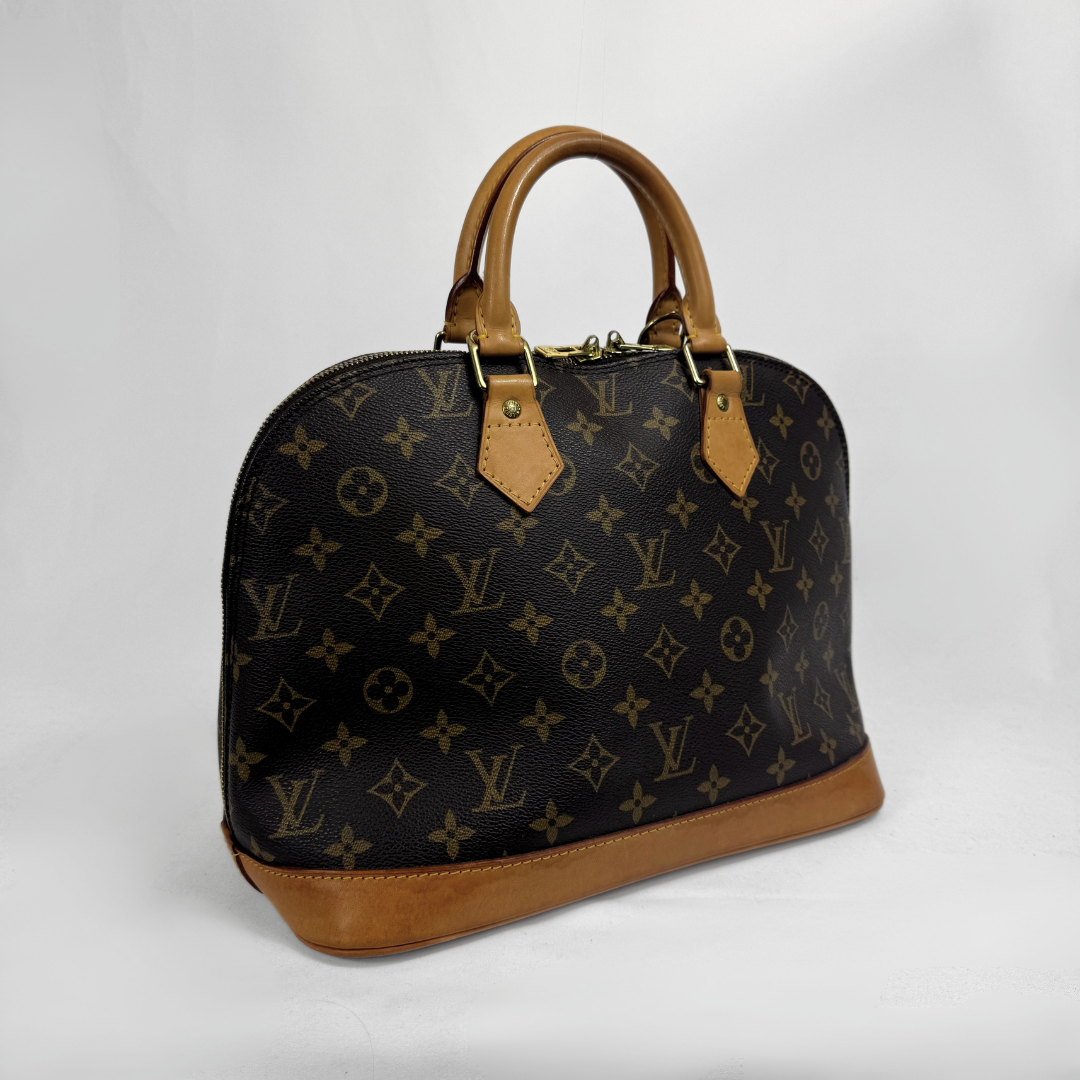 Louis Vuitton monogram canvas dome handbag with tan leather handles and trim, photographed on a light gray studio background.