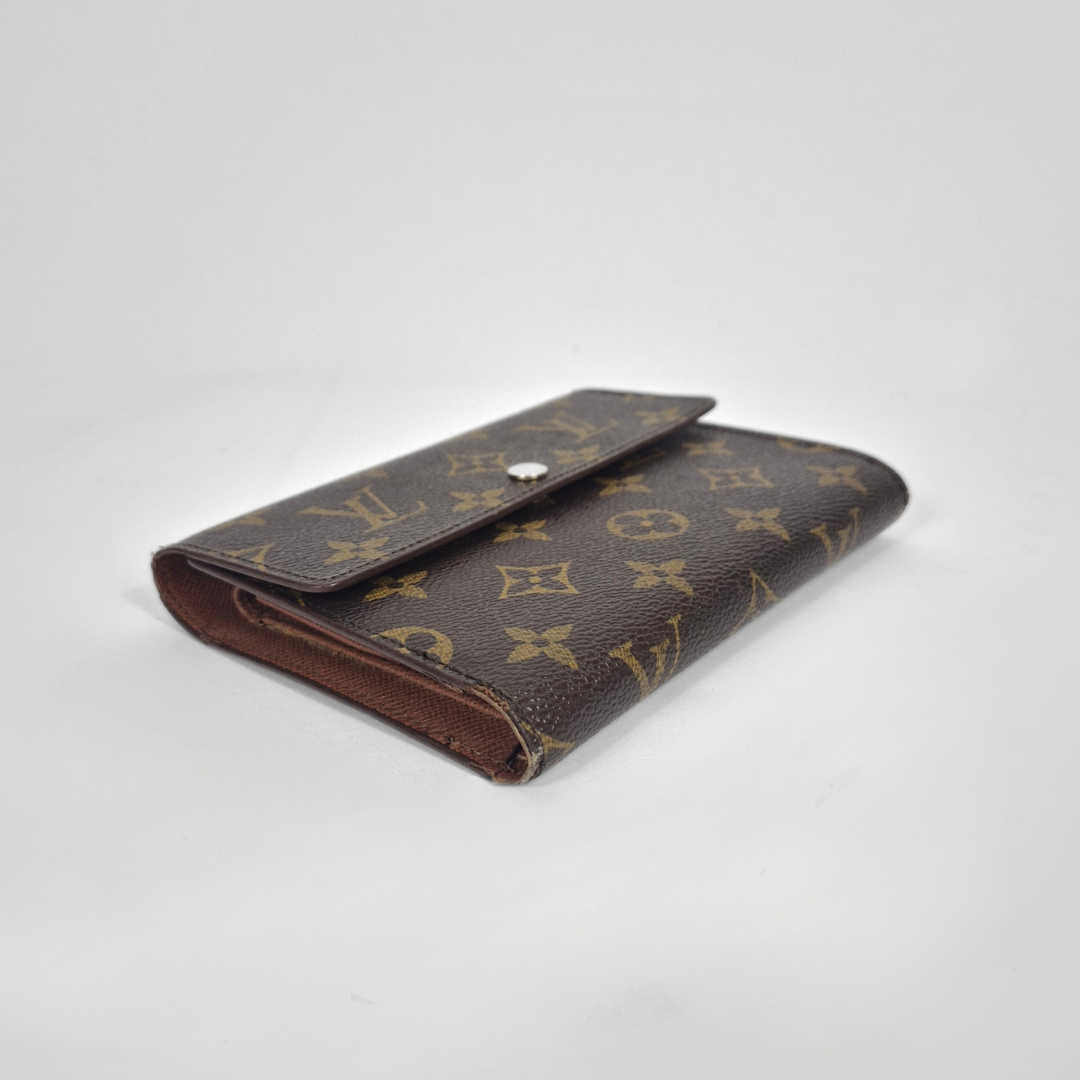 Louis Vuitton wallet with monogram pattern on a white background
