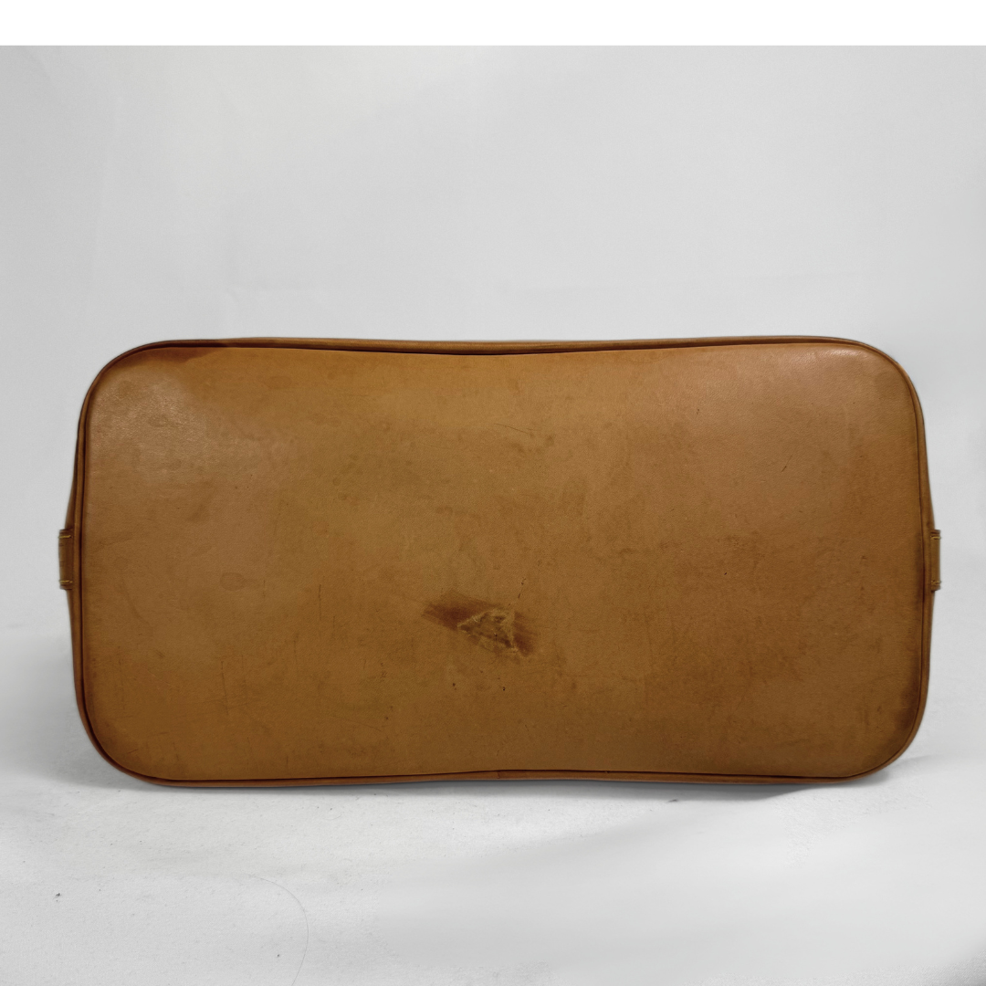 A vintage tan leather travel case or satchel with rounded corners, photographed against a plain light gray background.