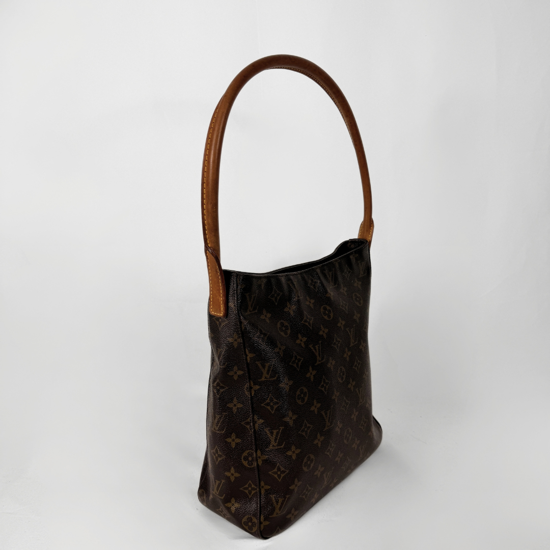 A Louis Vuitton monogram shoulder bag in dark brown coated canvas with tan leather trim and a single shoulder strap, photographed against a plain light gray background.