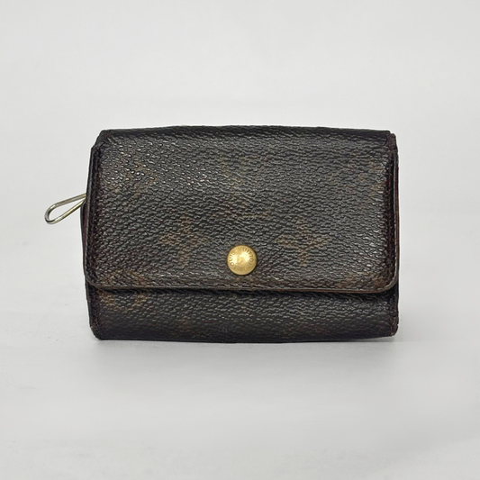 Black leather wallet with a gold button on a light gray background