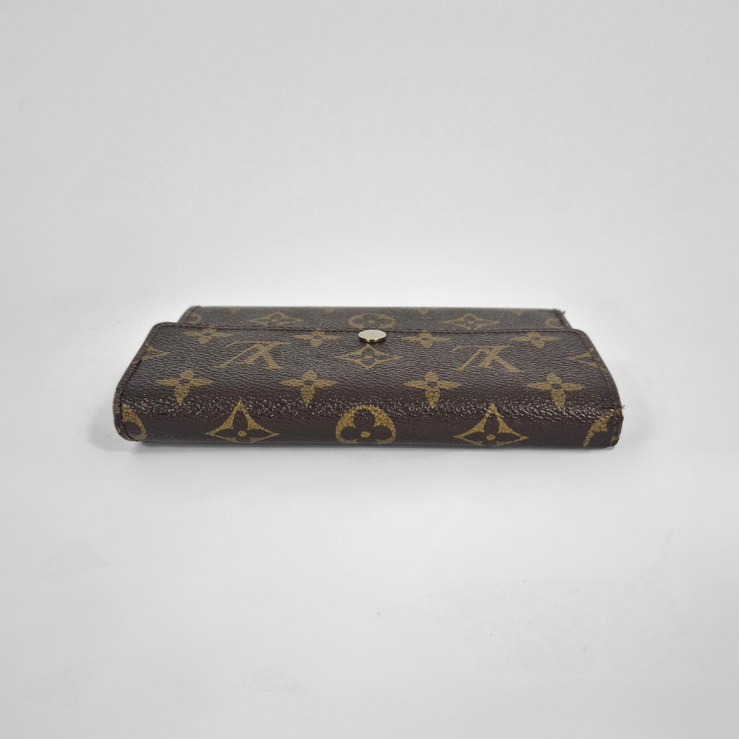Louis Vuitton wallet with monogram pattern on a white background