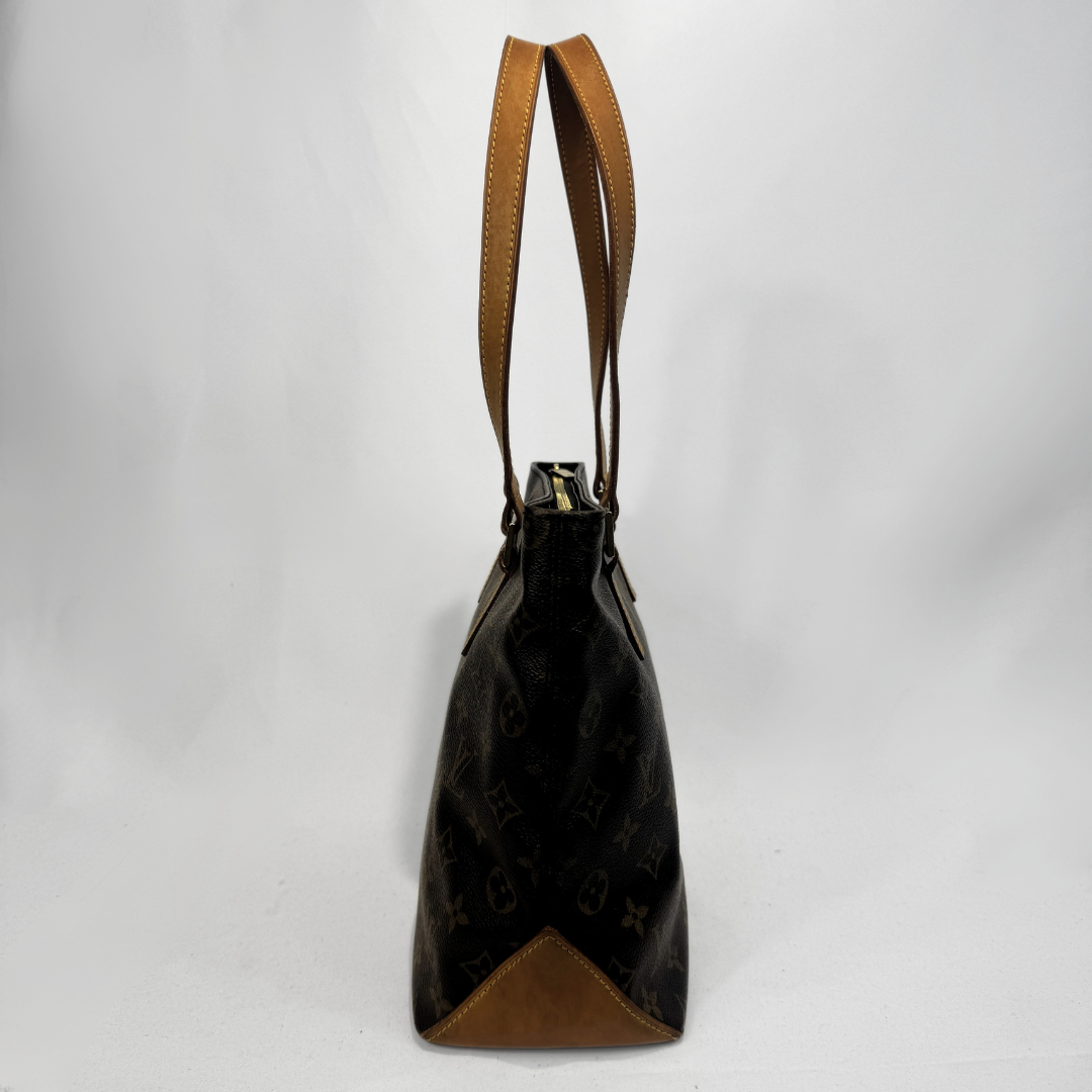 A Louis Vuitton monogram canvas shoulder bag in black and brown, featuring tan leather trim and handles, photographed against a white studio background.