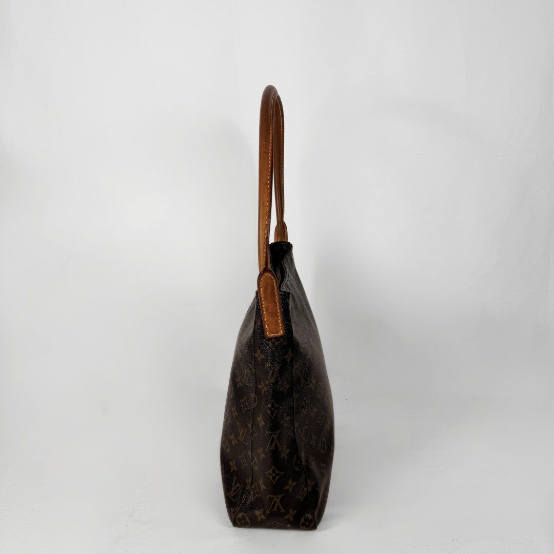 Louis Vuitton monogram canvas shoulder bag in dark brown with tan leather trim and handle, shown from a side profile view against a light gray background.
