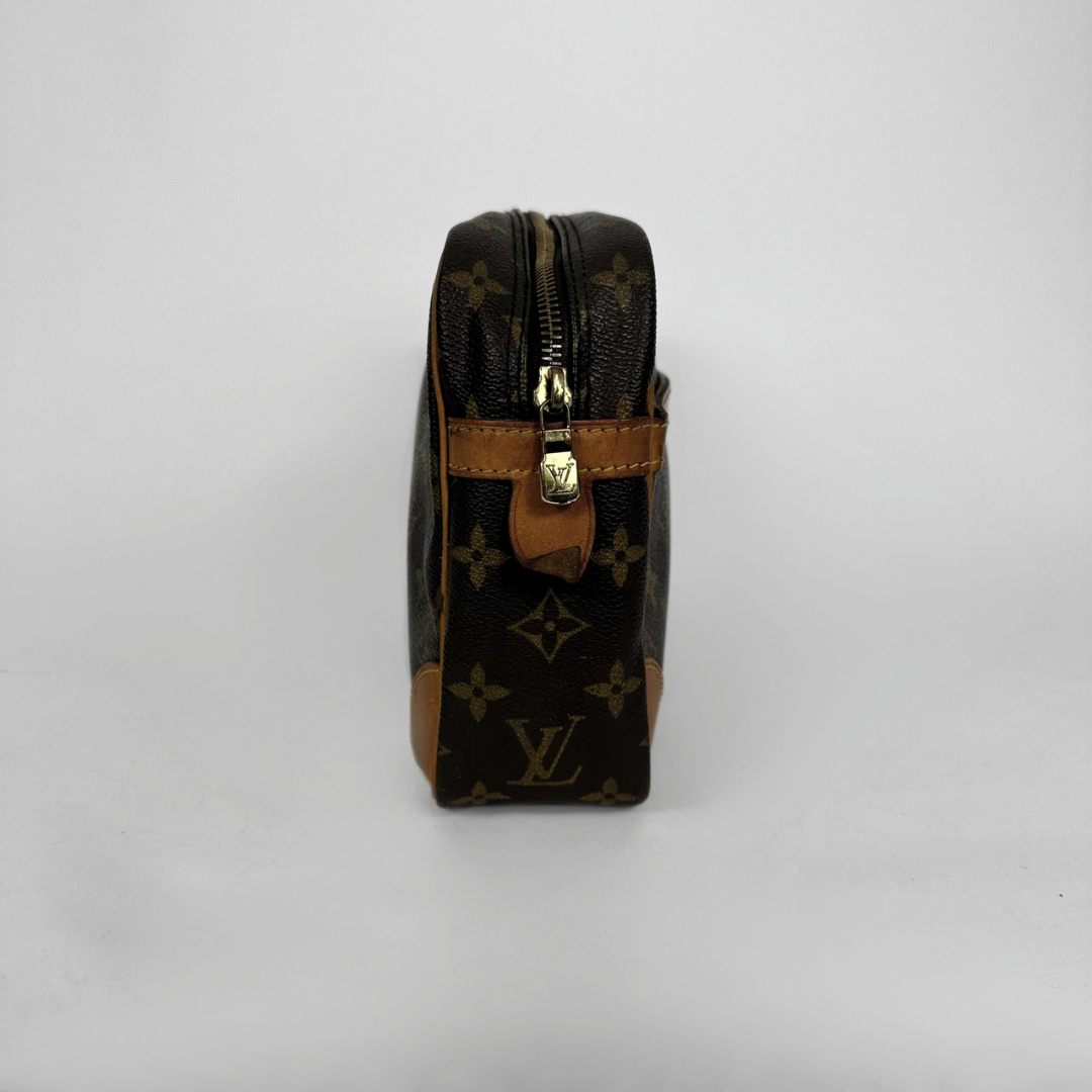 A Louis Vuitton monogram canvas pouch with brown leather trim and gold-tone hardware, photographed against a neutral light gray background.