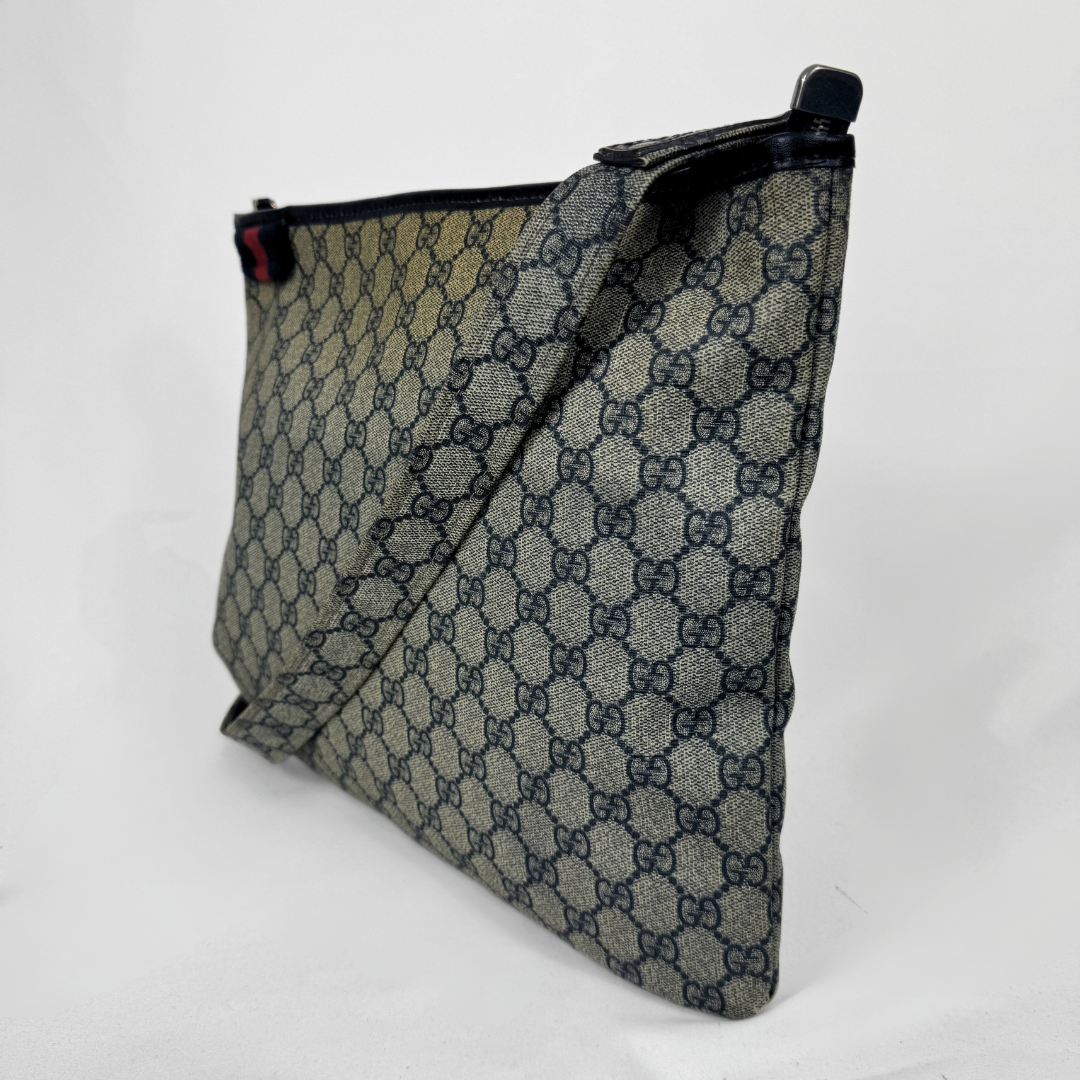 Gucci GG Supreme Web Flat Messenger bag in signature monogram canvas with green and red Web detailing and leather trims, displayed on a light grey background.