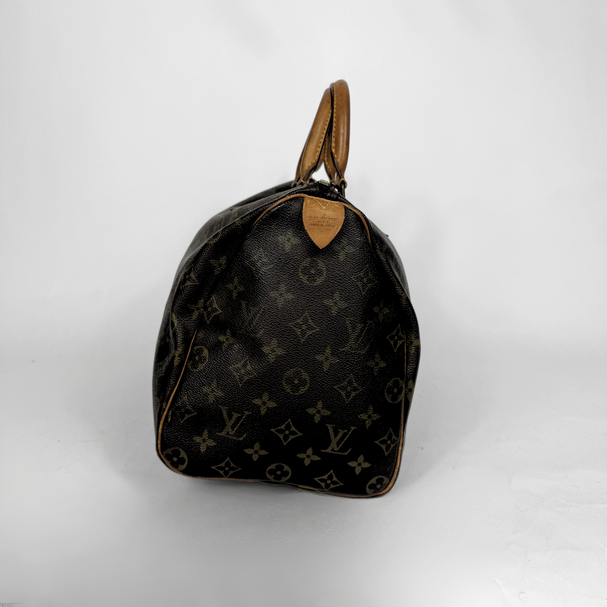 Designer-käsilaukku, jossa monogrammikuvio valkoisella taustalla