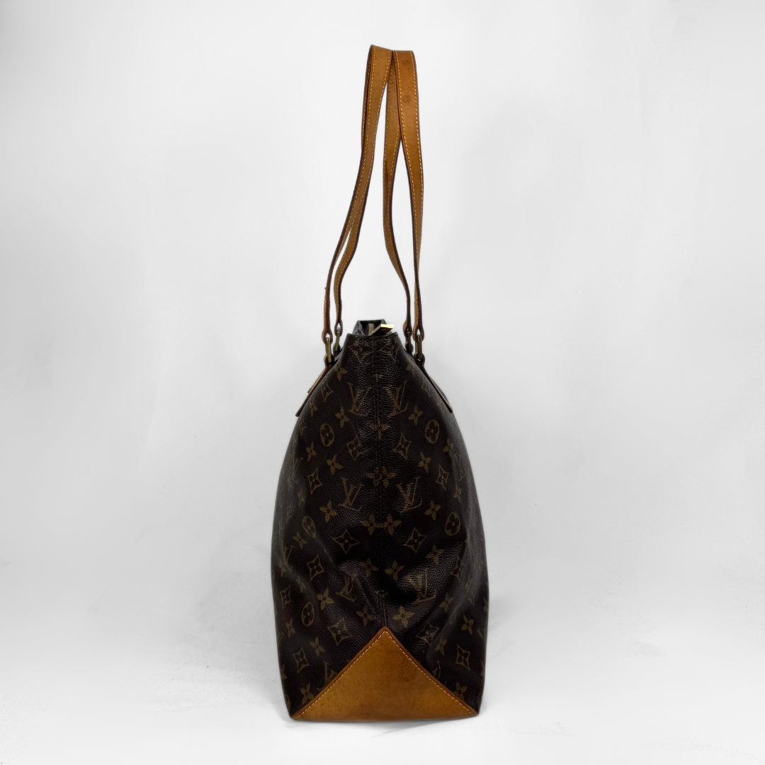 A Louis Vuitton monogram canvas tote bag with tan leather trim and shoulder straps, shown from the back against a white studio background.