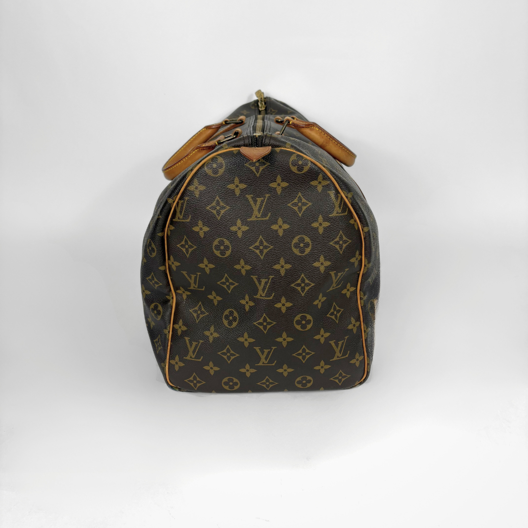 Louis Vuitton monogram travel bag with brown leather straps on a white background