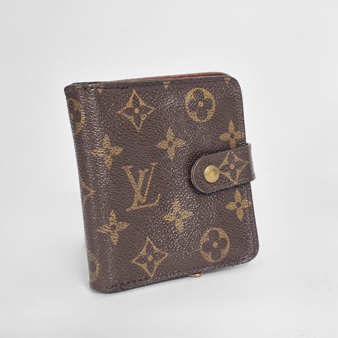 Louis Vuitton wallet with monogram pattern on a light gray background