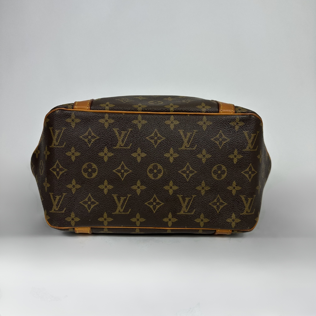 Louis Vuitton monogram canvas handbag shown from the bottom view, featuring the classic brown and tan LV pattern with tan leather trim on a light gray background.