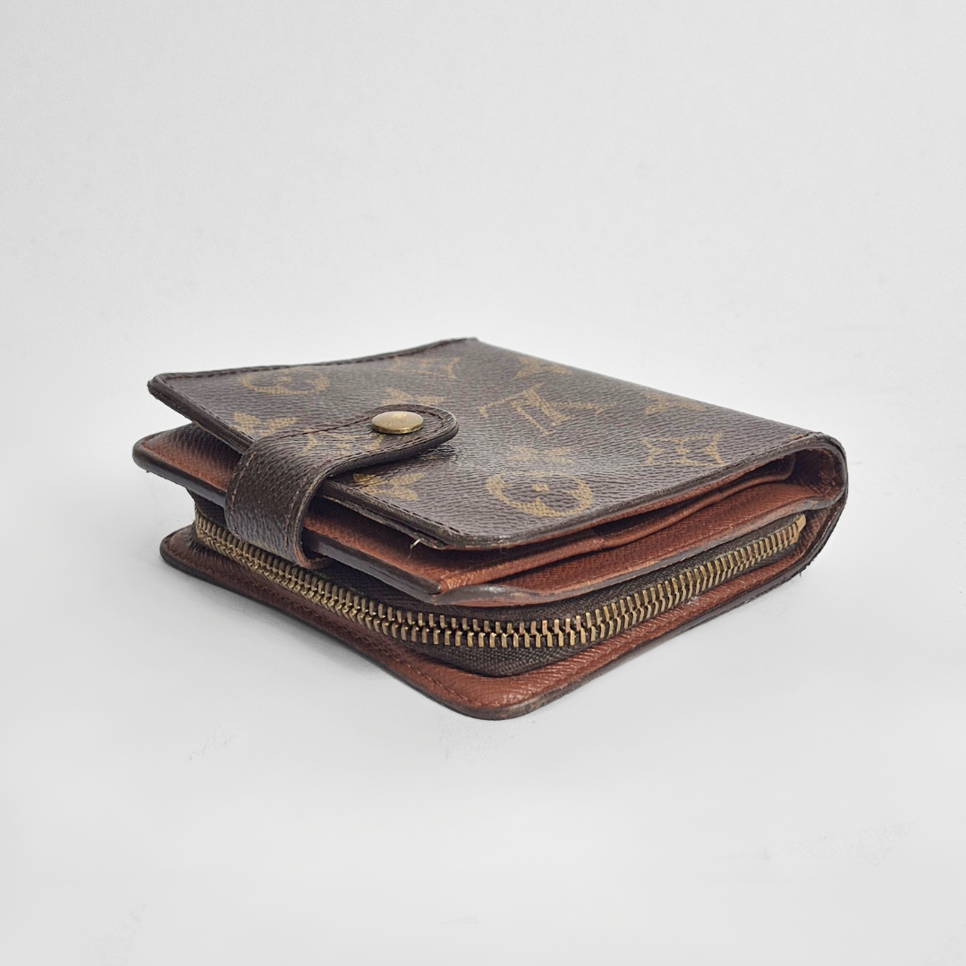 Louis Vuitton wallet with monogram pattern on a light gray background