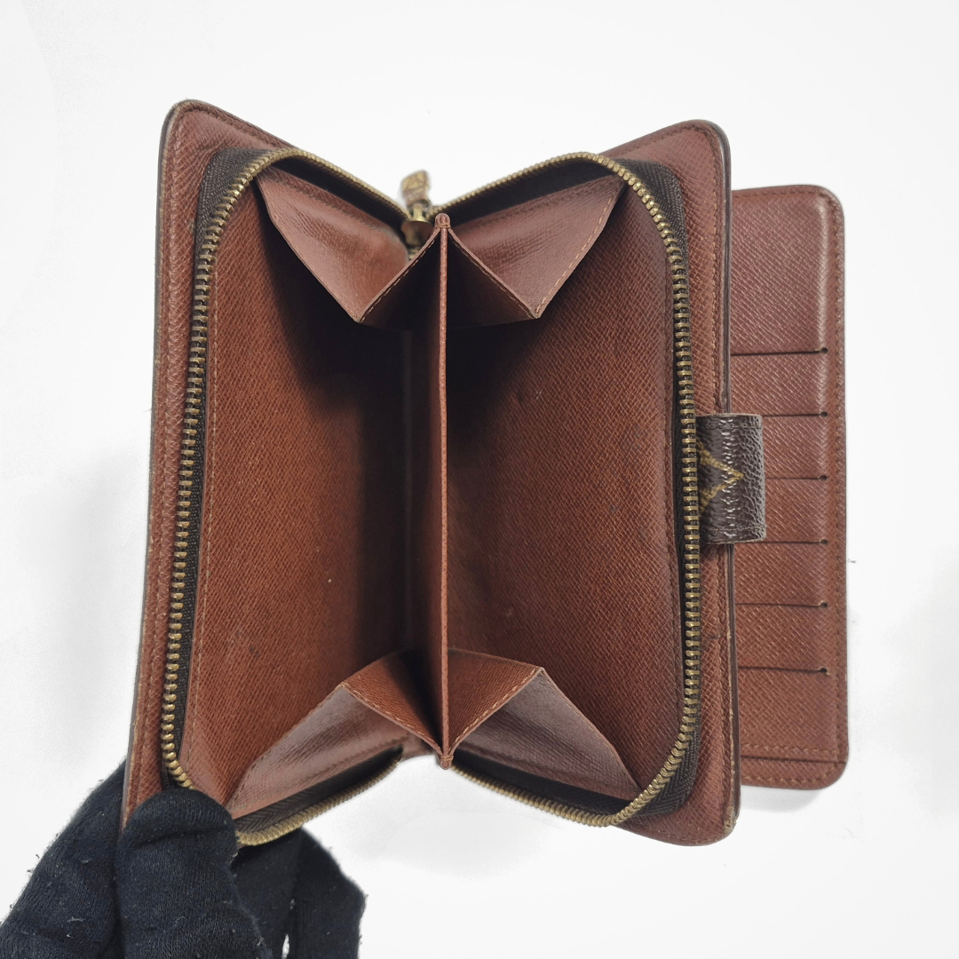 Brown leather wallet with gold zipper on a white background