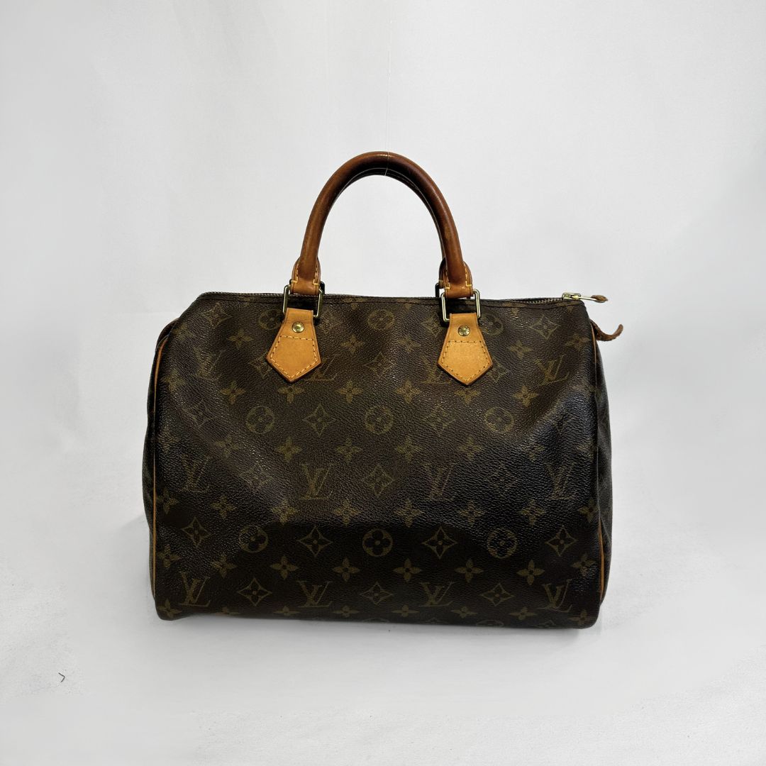 A Louis Vuitton monogram Speedy handbag in dark brown coated canvas with tan leather handles and trim, photographed against a plain white background.