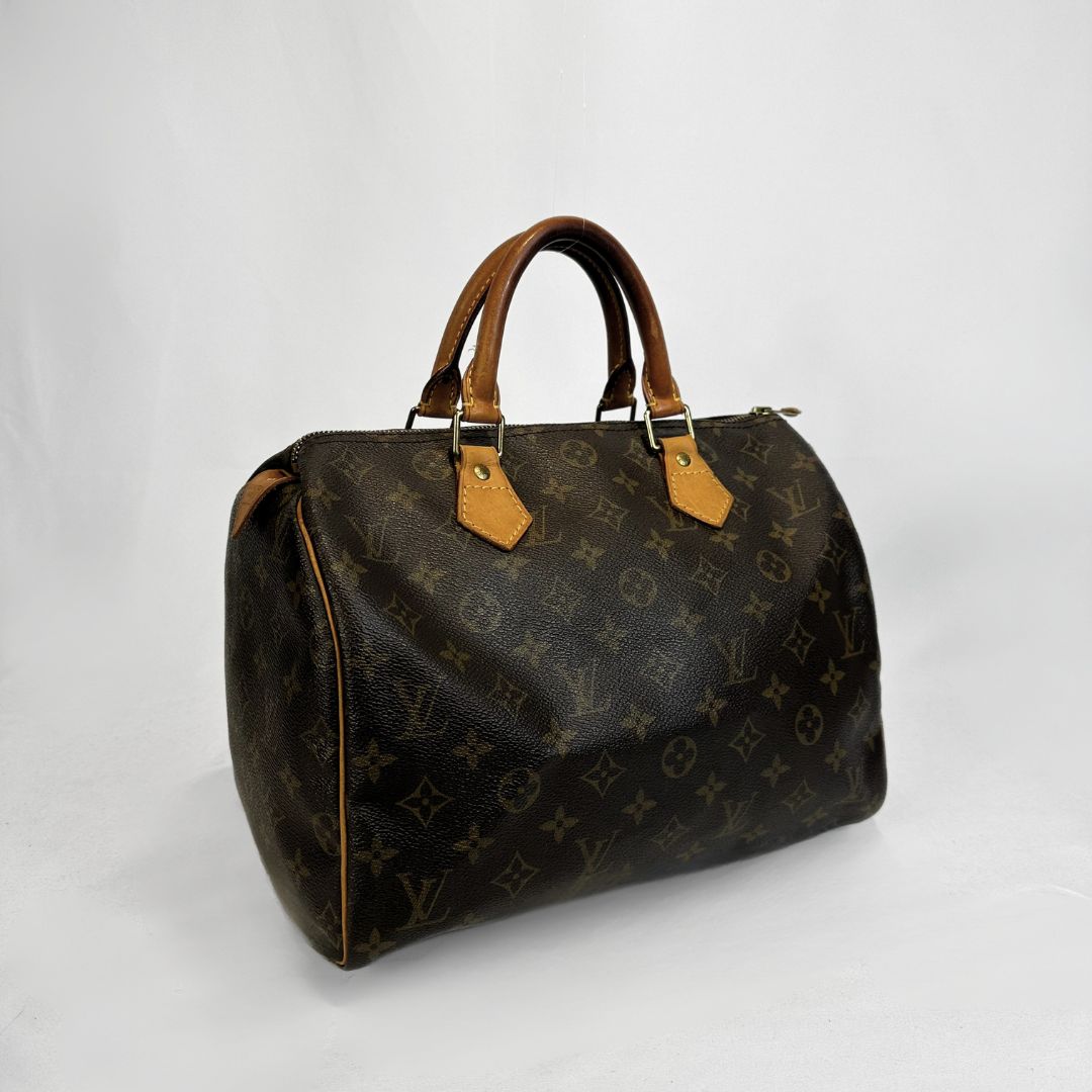A Louis Vuitton monogram canvas Speedy handbag with brown leather handles and trim, shown on a plain light gray background.