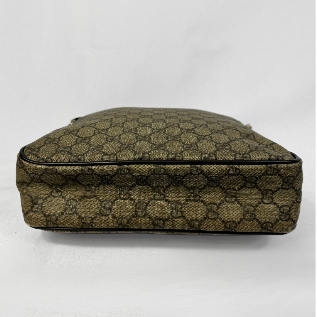 A Gucci monogram canvas bag shown from the side, featuring the brand's signature GG pattern in olive green and brown on a white background.