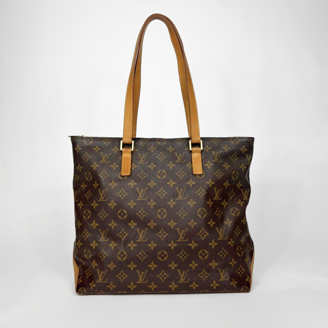 Brown monogram handbag with tan handles on a white background