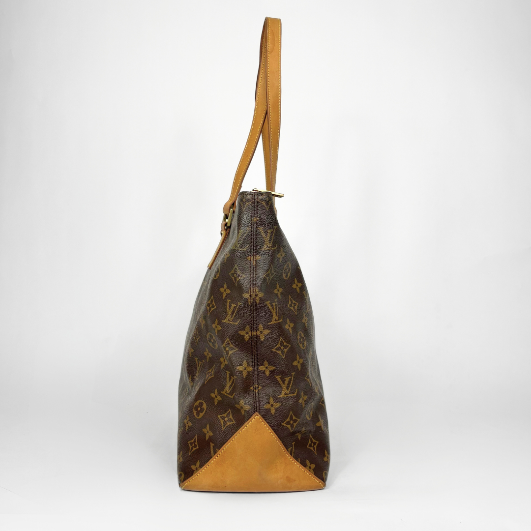 Brown leather handbag with tan interior on a white background