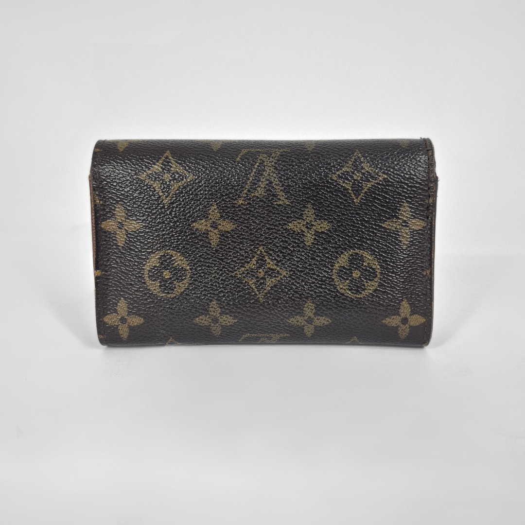 Designer wallet with monogram pattern on a light gray background